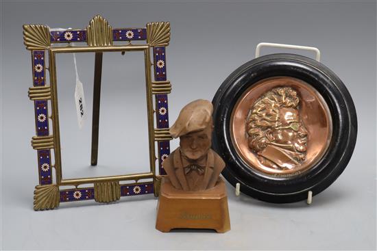 An champléve enamel brass photograph frame, a copper relief plaque signed Schubert and a bust of Wagner